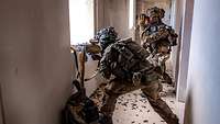 Ein Soldat kämpft mit einem Maschinengewehr aus einem Fenster.