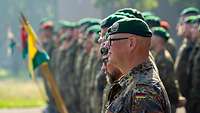 Zahlreiche Soldaten mit grünen Baretten und Kompaniewimpeln sind angetreten.