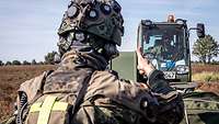 Ein Soldat steht vor dem Verladefahrzeug und signalisiert mit einem Daumen hoch: alles geschafft.