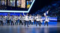 Finnische Musikerinnen und Musiker in weißen Uniformen auf der Bühne