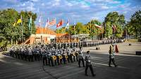 Soldaten und Militärmusiker stehen auf einem großen Platz 