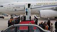 Der englische König Charles III. verlässt ein Flugzeug in Berlin. Soldaten stehen Spalier.