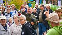 Eine Gruppe Menschen läuft im DinoPark Münchehagen. 
