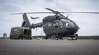 Ein Hubschrauber H145M ist mit einem Stromaggregat verbunden. Dahinter fliegt ein Kampfjet Tornado. 