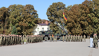 Viele Soldatinnen und Soldaten stehen in Formation auf einem Platz.