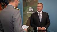 Verteidigungsminister Boris Pistorius spricht mit einem Soldaten während eines Interviews.