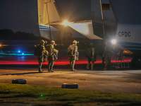 Fallschirmspringer steigen in ein Flugzeug bei Nacht