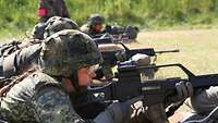 Mehrere Soldaten liegen nebeneinander mit dem Gewehr G36 im Anschlag.