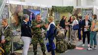 Viele Menschen im Gespräch auf einem Messestand der Bundeswehr