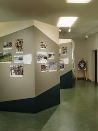 Blick in einen Ausstellungsraum Blick in einen Ausstellungsraum mit zahlreichen Fotos, Beschriftung und Stellwänden