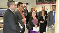 A group of people standing in a room full of charts and exhibits.