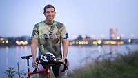 Ein Mann mit seinem Fahrrad am Reihen 