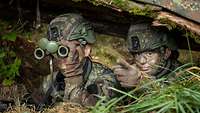 Soldaten beobachten das Vorfeld aus einer Stellung heraus