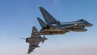 Drei Eurofighter fliegen nebeneinander. Der Hinterste bricht von der Formation weg. Im Hintergrund sieht man den Himmel.
