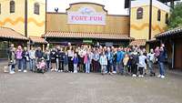 Eine Gruppe Menschen steht vor dem Eingang zum Freizeitpark Fort Fun. 