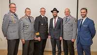 Sechs männlichen Personen posieren für ein Gruppenfoto.