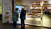 Zwei Frauen stehen in einer Bäckerei vor der Warenauslage.