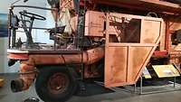Eine historische Getreideerntemaschine steht als Ausstellungsmodell im Agrarium.