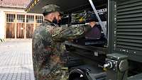 Common Roof SatCom Ein Soldat arbeitet an einer Satellitenkommunikationsanlage.