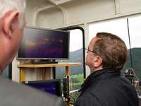 Camouflage effect A man is looking at a screen in a cable car.
