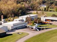 Weighing position Aerial view of several buildings. In front of them, there is a large aircraft.