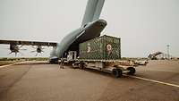 Ein Container mit Material wird in das Transportflugzeug A400M geschoben auf dem Flugplatz in Gao