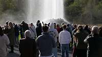 Eine Wasserfontäne schießt aus einem Geysir.