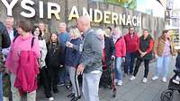 Mehrere Personen stehen vor dem Eingang des Museums.