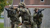 Drei Soldaten gehen mit ihren Gewehren G36 im Anschlag vor.