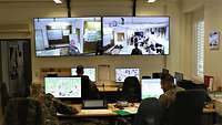 Ein Raum mit Computermonitoren und großen Bildschirmen