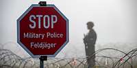 Ein Stopschild und im Hintergrund ein Soldat