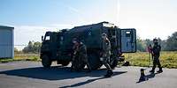 Ein militärisches Fahrzeug mit Soldaten davor