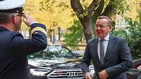 Ein Soldat in Marineuniform begrüßt militärisch Verteidigungsminister Boris Pistorius.