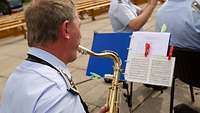 Ein Musiker in Uniform spielt auf einem Saxofon