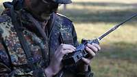 Ein Soldat hält ein Funkgerät in der Hand