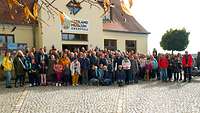 Eine Personengruppe vor einem Museum.