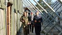 Mehrere Soldaten in verschiedenen Uniformen laufen einen Gang entlang.