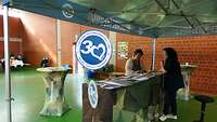 Zwei Frauen unterhalten sich unter einem Pavillon stehend