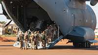 Mehrere Soldaten steigen über die Heckrampe in das Transportflugzeug A400M am Flughafen Gao.