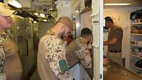 Ein Soldat spricht durch ein Fenster zu einem anderen Soldaten an Bord eines Schiffes.