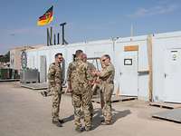 Vier Soldaten stehen zusammen und reden.