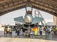 Ein Eurofighter steht in einem Shelter. Daneben weht auf einem Hügel die Fahne Mecklenburg-Vorpommerns.