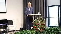 Ein Mann steht hinter einem Redner-Pult
