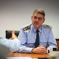 Zwei Soldaten sitzen sich gegenüber und sprechen miteinander. 