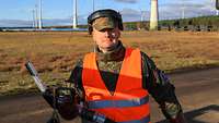 Soldat mit Benzin-Zapfpistole in der Hand