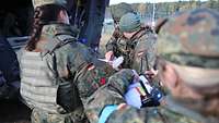 Soldaten befinden sich an der Heckklappe eines Fahrzeuges.