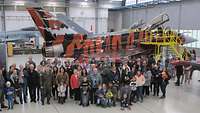 Rund 90 Menschen stehen vor dem Eurofighter für ein Gruppenbild zusammen.