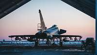 Eurofighter steht im Hanger mit Blick in den Sonnenaufgang