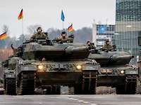 Multinationale Militärparade in Vilnius Soldaten fahren in zwei Kampfpanzern vom Typ Leopard durch eine Stadt