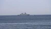 Man sieht das Meer und in der Ferne ein Schiff. Ein Buster-Einsatzboot fährt von diesem davon.
